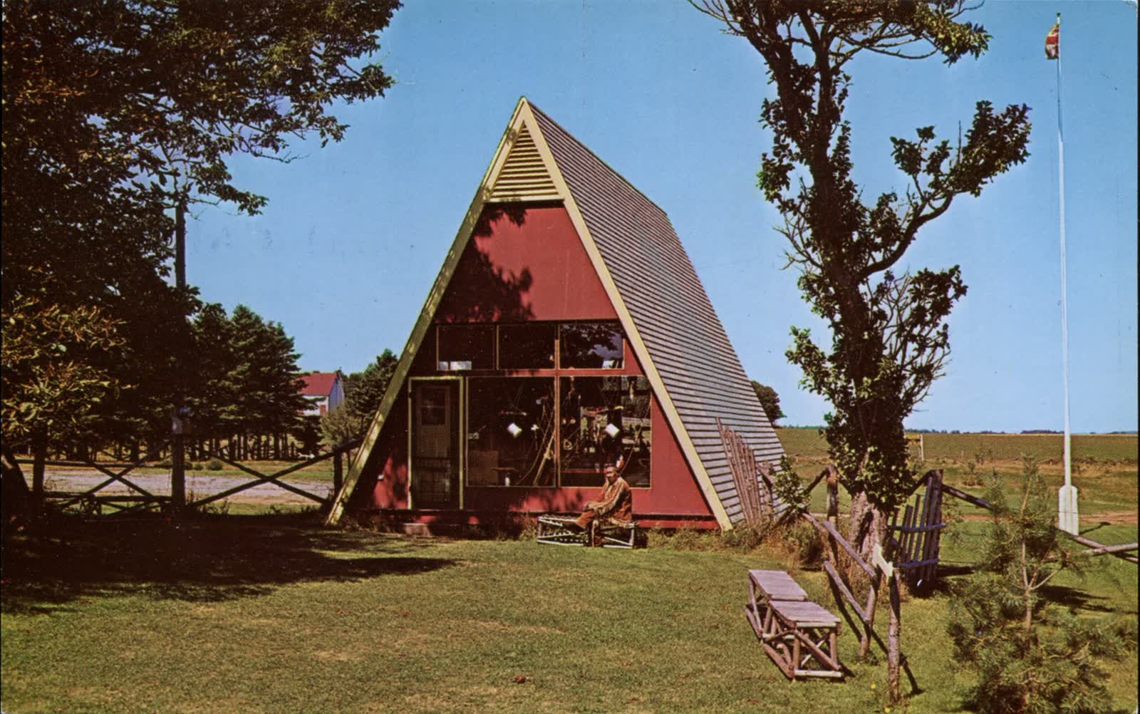 Casa triangolare rossa in un paesaggio rurale
