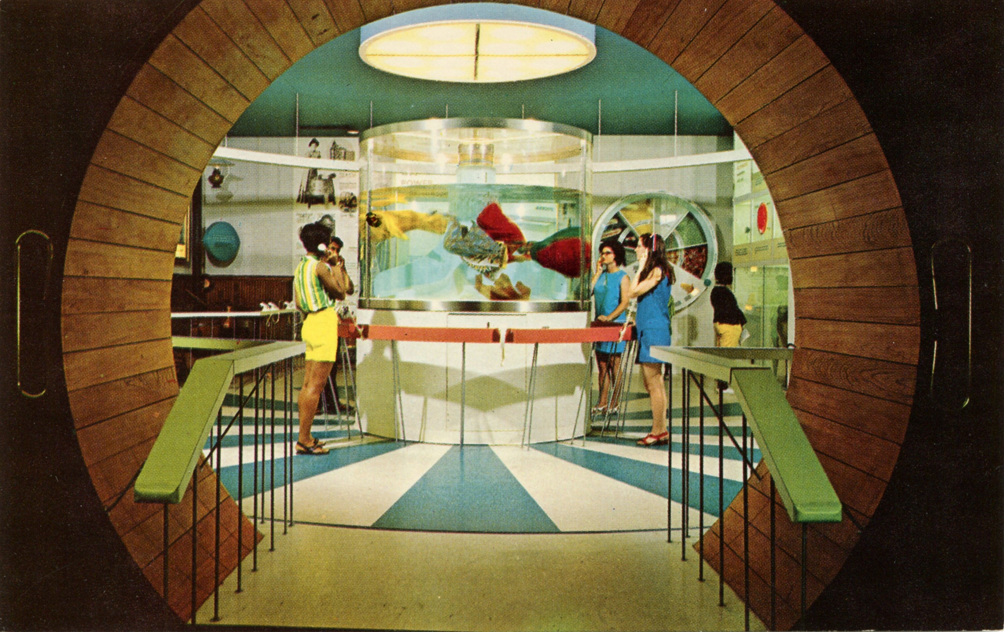 Una sala vintage vista attraverso un grande portale circolare, con persone intorno a un acquario cilindrico